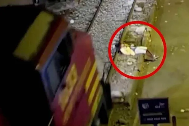 لحظة اقتراب القطار من الرجل وهو مستلقٍ على السكة الحديدية