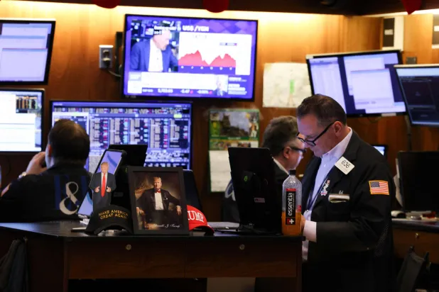 متداولون في بورصة نيويورك عند جرس الافتتاح يوم الجمعة (أ.ف.ب)