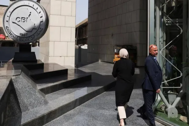 موظفون يسيرون في مقر البنك المركزي العراقي ببغداد (رويترز)