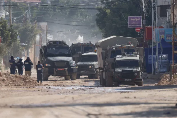 مركبات عسكرية إسرائيلية تسير على طول الطريق في أثناء عملية عسكرية إسرائيلية في مدينة جنين بالضفة الغربية يوم الثلاثاء