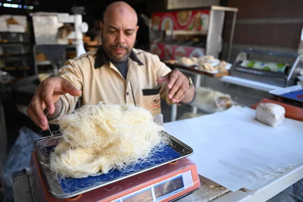 خباز مصري يجهز طلبية كنافة (أ.ف.ب)