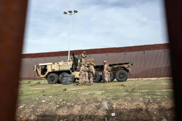 جنود أميركيون من سلاح الهندسة يعززون جدار الحماية بالقرب من الحدود المكسيكية مع كاليفورنيا (أ.ف.ب)