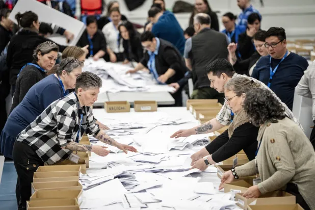 موظفون انتخابيون يفرزون الأصوات في نوك يوم 11 مارس (إ.ب.أ)