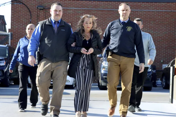 الشرطة تقتاد كيمبرلي سوليفان بعد اتهامها بخطف وإساءة معاملة ابن زوجها (أ.ب)