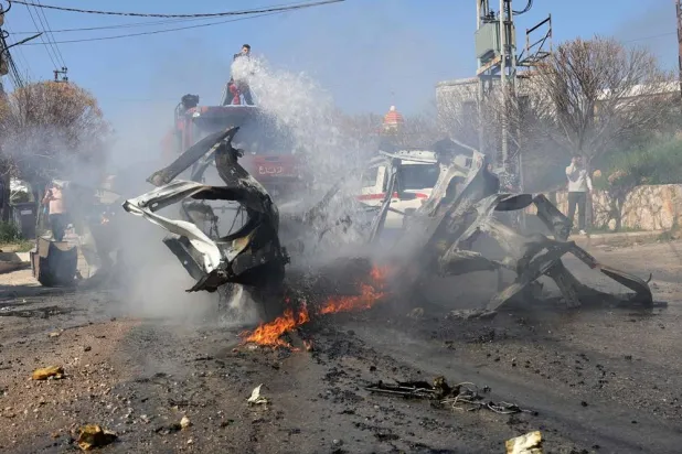 A firefighter douses the flames of a car hit by an Israeli strike in the southern Lebanese village of Burj al-Muluk on March 15, 2025, in which one person was reportedly killed. (AFP) 