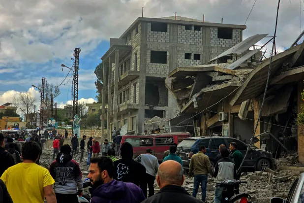 لبنانيون يتفقدون مبنى مدمّراً نتيجة القصف الإسرائيلي على جنوب لبنان (د.ب.أ)