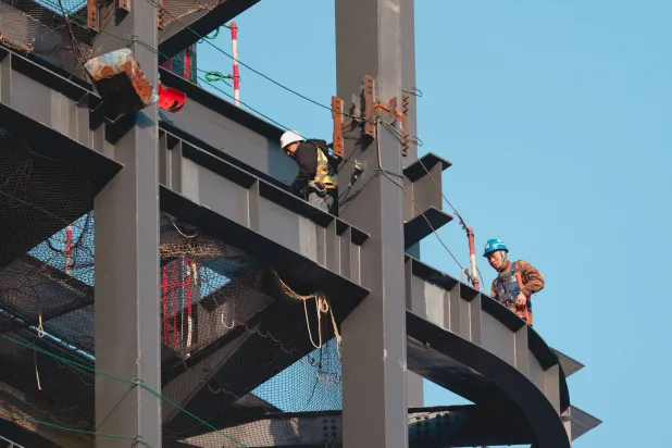 عمال في موقع بناء بمدينة شنغهاي الصينية (إ.ب.أ)