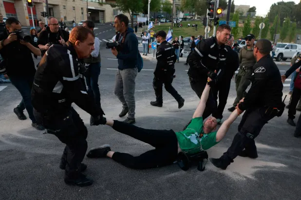 الشرطة الإسرائيلية تلقي القبض على متظاهر ضد حكومة نتنياهو يوم الاثنين في القدس (أ.ف.ب)