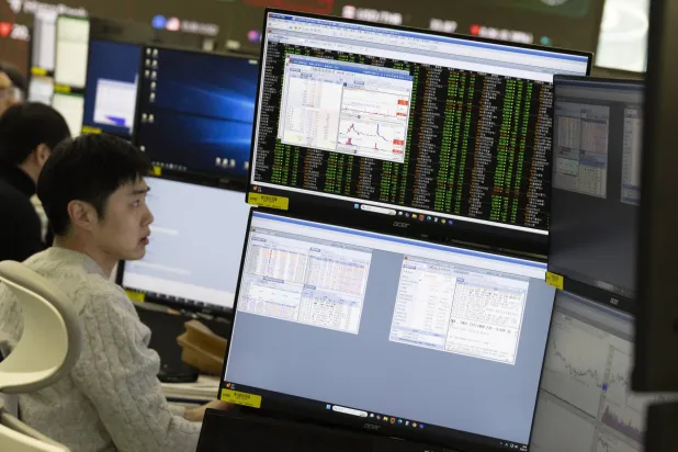 تجار من كوريا الجنوبية يعملون أمام شاشات ببنك «هانا» في سيول (إ.ب.أ)