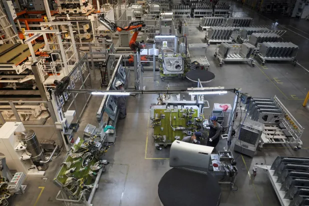 عمال في مصنع سيارات «نيو» الكهربائية بمدينة هيفي الصينية (رويترز)