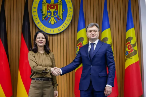 رئيس الوزراء المولدوفي دورين ريسيان يصافح وزيرة الخارجية الألمانية في حكومة تصريف الأعمال أنالينا بيربوك عند وصولها إلى مبنى الحكومة في كيشيناو بمولدوفا 2 أبريل 2025 (إ.ب.أ) 