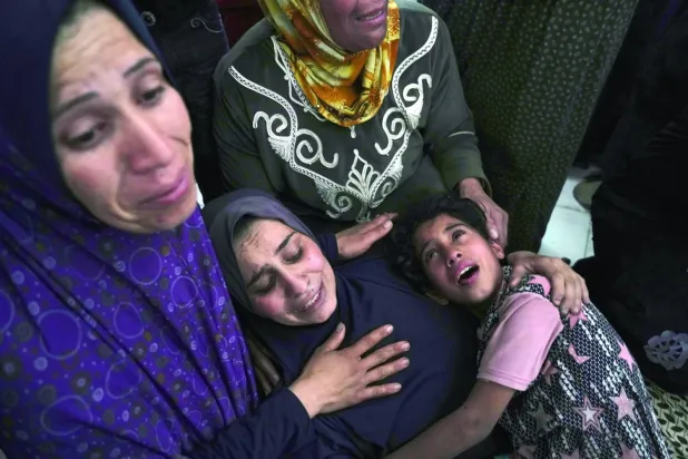 Filistinli kadınlar, İsrail'in Gazze Şeridi'nin Beyt Lahiya kentinde dün düzenlediği saldırıda öldürülen yakınlarının naaşları önünde ağladı (AP)