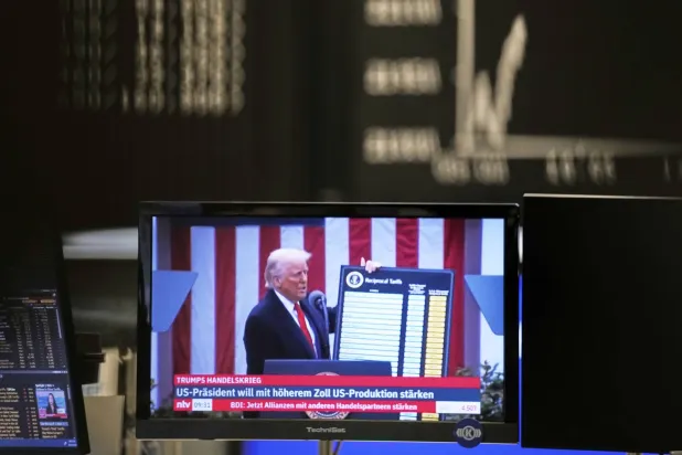 يظهر الرئيس الأميركي دونالد ترمب على شاشة تلفزيونية بسوق الأسهم في فرانكفورت (أ.ب)