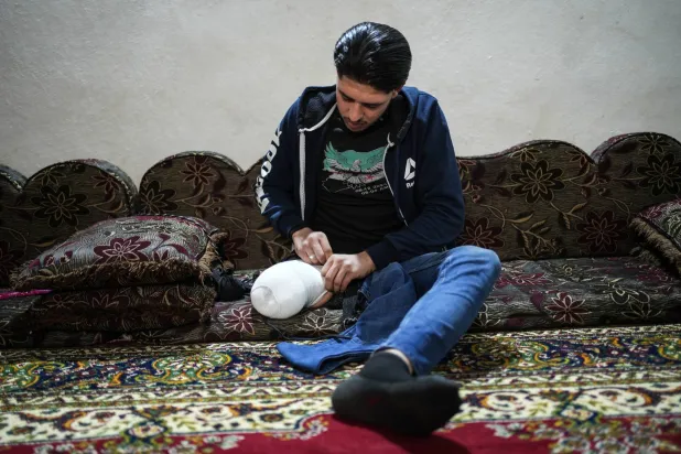 صورة ملتقَطة في 26 مارس 2025 في قميناس جنوب شرقي محافظة إدلب تُظهر الشاب سليمان المصاب جراء انفجار لغم أثناء دخوله أرضاً زراعية في قرية داديخ بريف إدلب (د.ب.أ)