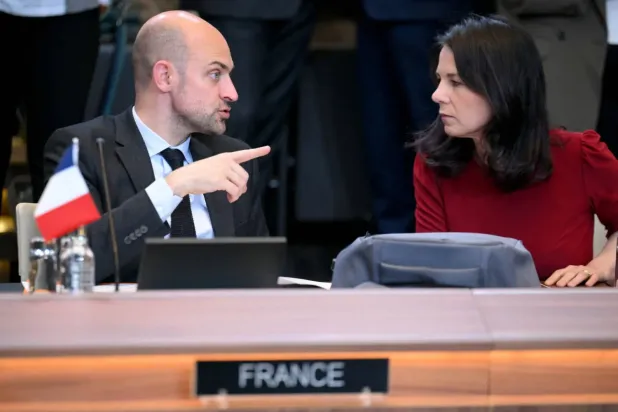 Barrot, Brüksel'deki NATO dışişleri bakanları toplantısı sırasında Alman mevkidaşı Annalena Baerbock ile konuşuyor (AFP)