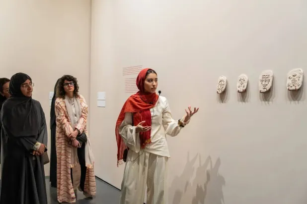 Artist Alla Abdunabi discusses her works with visitors at the exhibition (421 Arts Campus) 