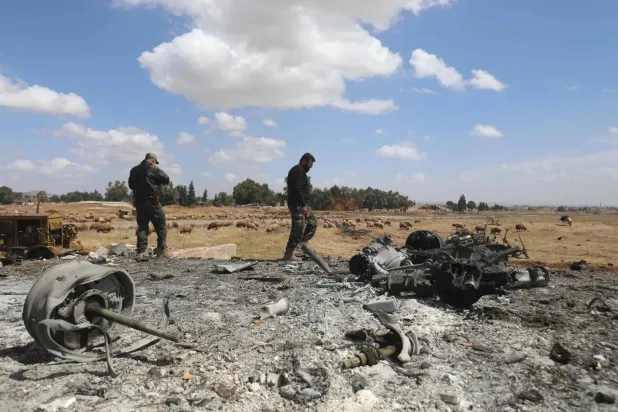 Men inspect the site of an Israeli airstrike on Thursday morning, following the bombing in southern Hama Province (AFP). 