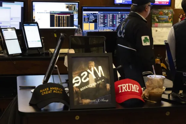 Donald Trump'ın New York Borsası'nda Make America Great Again (Amerikayı Yeniden Harika Yap) şapkaları arasında çekilmiş bir fotoğrafı (AP)