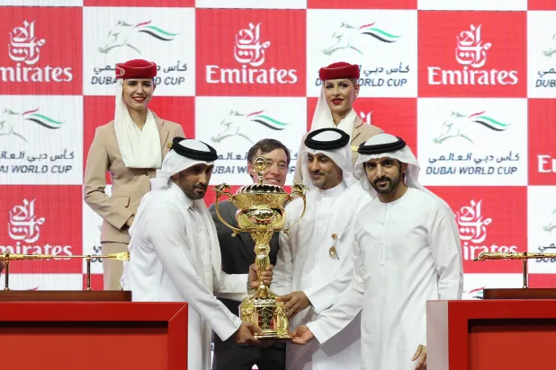 الشيخ حمدان بن محمد بن راشد ولي عهد دبي يسلم الكأس للفارس جيرو (إ.ب.أ)