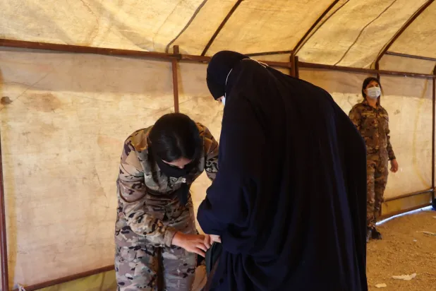 امرأة تخضع للتفتيش في مخيم «روج» شمال شرقي سوريا (الشرق الأوسط)