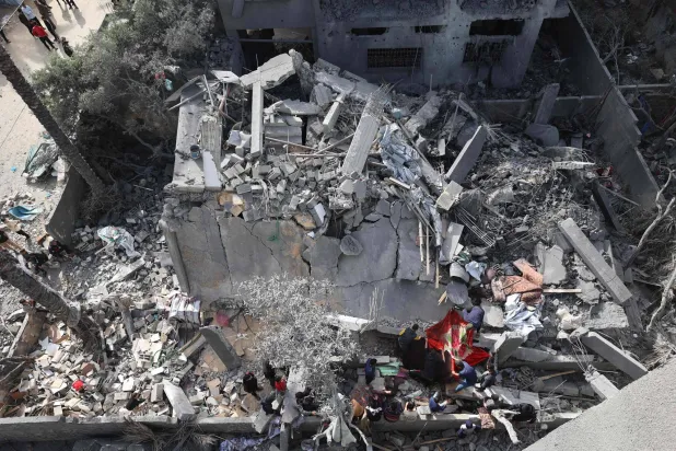 أشخاص يتفقدون الدمار في دير البلح وسط قطاع غزة في 7 أبريل 2025 بعد غارات جوية إسرائيلية ليلية (أ.ف.ب)