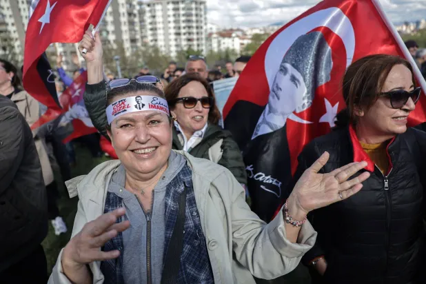 إحدى مناصرات «حزب الشعب الجمهوري» ترتدي طوقاً يحمل صورة رئيس بلدية إسطنبول أكرم إمام أوغلو خلال تجمع بأنقرة الأحد (أ.ف.ب)