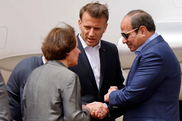 الرئيس المصري عبد الفتاح السيسي يصافح نظيره الفرنسي إيمانويل ماكرون لدى وصوله إلى مطار العريش الدولي اليوم (أ.ف.ب) 