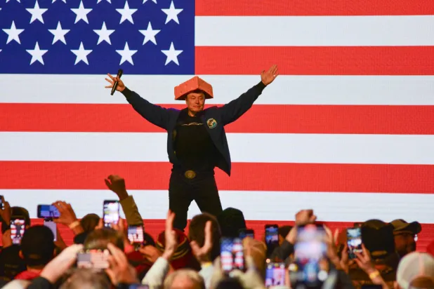 الملياردير الأميركي إيلون ماسك يرتدي قبعة على شكل الجبن (أ.ف.ب) 