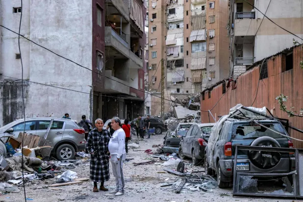 لبنانيون يقفون في مدخل مبنى تعرَّض لاستهداف إسرائيلي في ضاحية بيروت الجنوبية يوم 1 أبريل الجاري (أ.ف.ب)