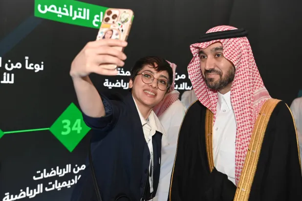 إحدى الإعلاميات في المنتدى تلتقط صورة مع وزير الرياضة الأمير عبدالعزيز بن تركي (تصوير: بشير صالح)