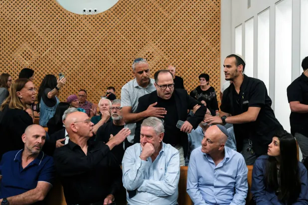 رجل يصرخ في وجه رؤساء أجهزة أمنية إسرائيلية سابقين في قاعة المحكمة قبل جلسة استماع بشأن إقالة الحكومة لرئيس (الشاباك) رونين بار الثلاثاء (رويترز)