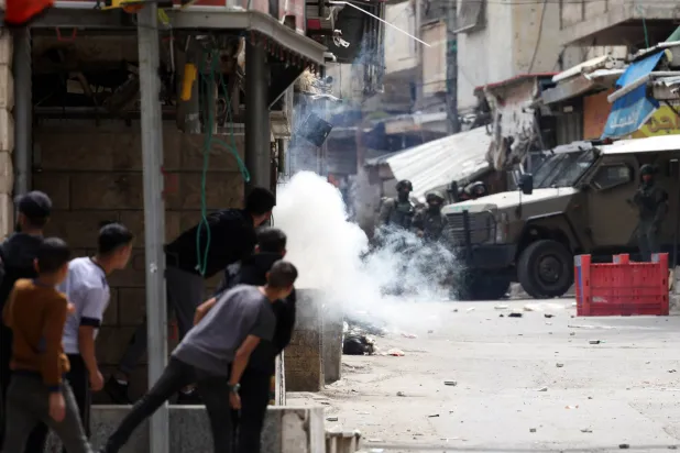 فلسطينيون يتصدون للجيش الإسرائيلي في مخيم بلاطة للاجئين بنابلس الأربعاء (إ.ب.أ)