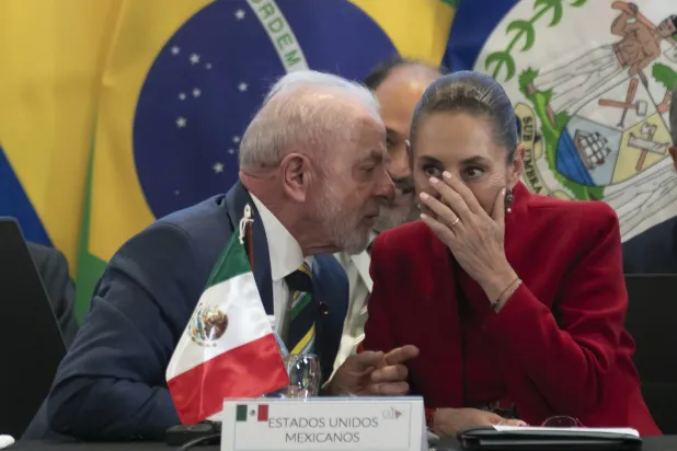 الرئيسة المكسيكية كلوديا شاينباوم والرئيس البرازيلي لويس إيناسيو لولا دا سيلفا في حديث هامس على هامش قمة إقليمية عقدت في هندوراس (إ.ب.أ)