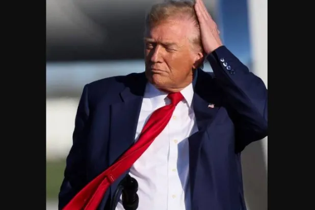 الرئيس الأميركي دونالد ترمب يضع يده عن شعره (رويترز)