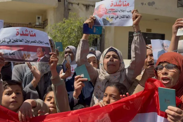 سيدات وأطفال من حملة الجنسية المصرية يطالبون بإخراجهم من قطاع غزة في مظاهرة في دير البلح يوم الخميس (الشرق الأوسط)