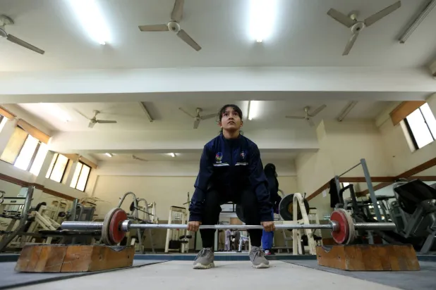 امرأة باكستانية ترفع الأثقال في صالة للألعاب الرياضية (إ.ب.أ)