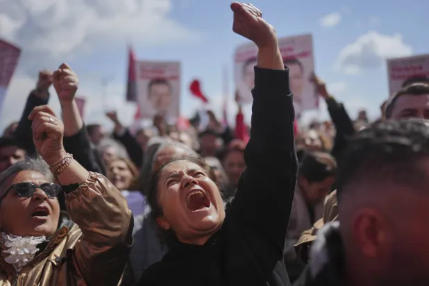 أنصار إمام أوغلو يرفعون صوره ويطالبون بإطلاق سراحه خلال محاكمته في قضية تهديد المدعي العام في إسطنبول التي نُظرت الجمعة في قاعة ملحقة بسجن سيليفري (أ.ب)