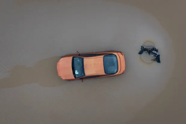 مياه الأمطار تحيط بسيارة (أ.ف.ب)