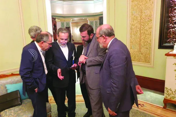 عباس عراقجي وسط أعضاء الوفد الإيراني أثناء مكالمة هاتفية في عمان 12 أبريل 2025 (رويترز)