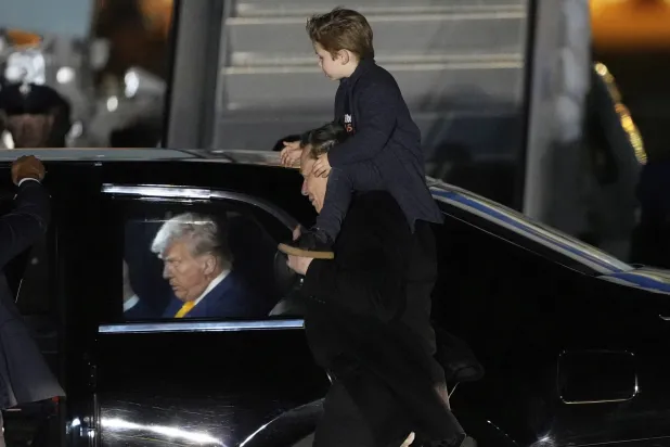 ماسك حاملاً ابنه إكس لدى وصولهما إلى مطار ميامي برفقة الرئيس الأميركي دونالد ترمب يوم 12 أبريل (أ.ب)