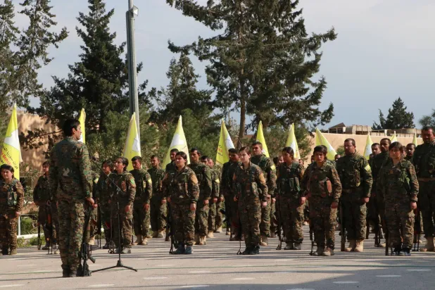 مقاتلون من «قسد» في عرض عسكري بحقل العمر النفطي في ريف دير الزور الشرقي (أرشيفية - الشرق الأوسط)