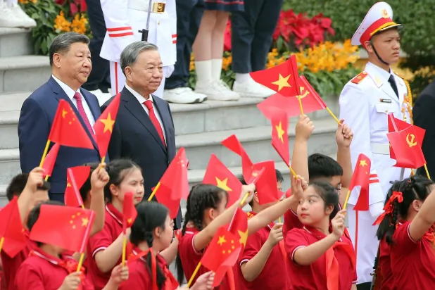 زعيم الحزب الشيوعي الفيتنامي تو لام والرئيس الصيني شي جينبينغ مع أطفال فيتناميين في هانوي الاثنين (أ.ف.ب)