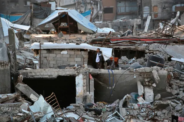 رجل يقف وسط أنقاض المباني المنهارة جراء الحرب في جباليا بشمال قطاع غزة (أ.ف.ب)