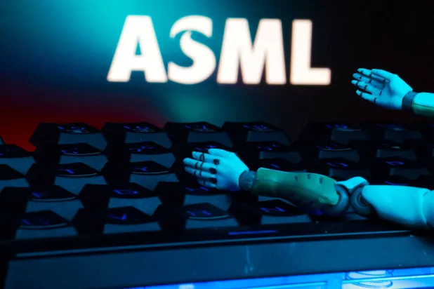 يظهر شعار «إيه إس إم إل» ولوحة مفاتيح مع يَدان لروبوت في هذه الصورة التوضيحية (رويترز)