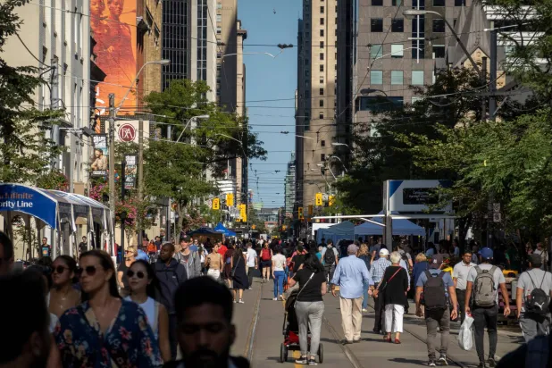 أشخاص يسيرون في أحد شوارع تورنتو بكندا يوم 8 سبتمبر 2022 (رويترز)