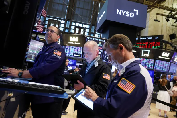 متداولون يعملون في قاعة بورصة نيويورك (رويترز)