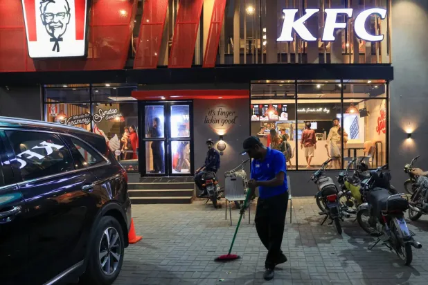  Pakistan'ın Karaçi kentinde geçen hafta İsrail karşıtı protesto sırasında saldırıya uğrayan ve tahrip edilen KFC fast food restoranında yerleri temizleyen bir işçi (Reuters)