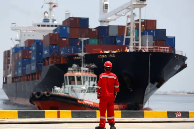 عامل يشاهد سفينة تغادر محطة حاويات «نيو بريوك 1» في شمال جاكرتا (أرشيفية - رويترز)