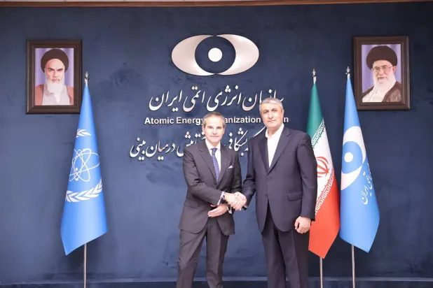 المدير العام للوكالة الدولية للطاقة الذرية رافائيل غروسي (يسار) يصافح رئيس منظمة الطاقة الذرية الإيرانية محمد إسلامي (يمين) في طهران (د.ب.أ)