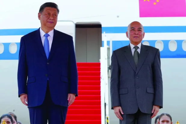 الرئيس الصيني شي جينبينغ منهياً جولته الآسيوية الأخيرة وبجواره ملك كمبوديا نورودم سيهاميني في مطار العاصمة الكمبودية بنوم بنه (أ.ب)